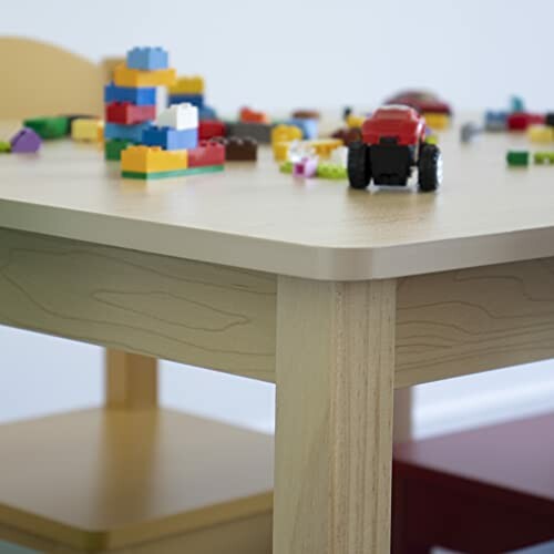 A table with colorful building blocks and a toy car.