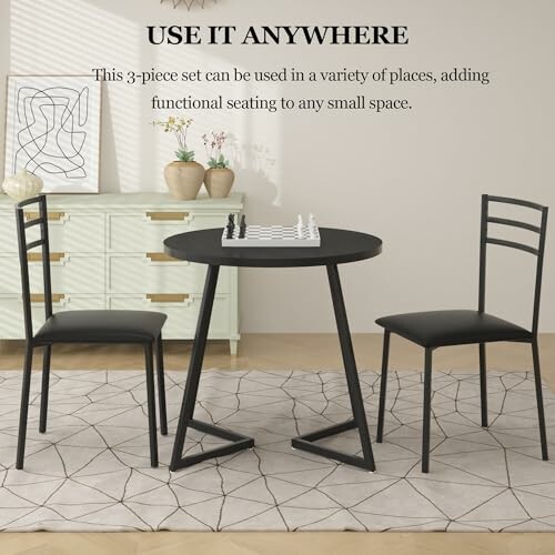 Compact 3-piece dining set with black chairs and round table.