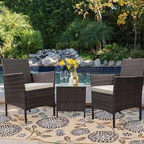 Outdoor patio furniture set with two chairs and a table by a pool.