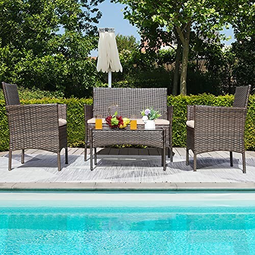 Outdoor patio furniture set by a pool with chairs, table, and umbrella.