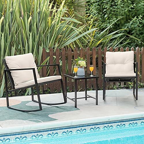 Outdoor patio set with two chairs, a table, and drinks by a pool.