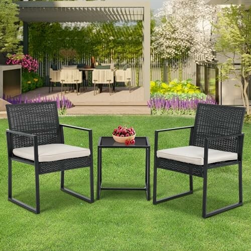 Outdoor patio furniture set with two chairs and a table on grass